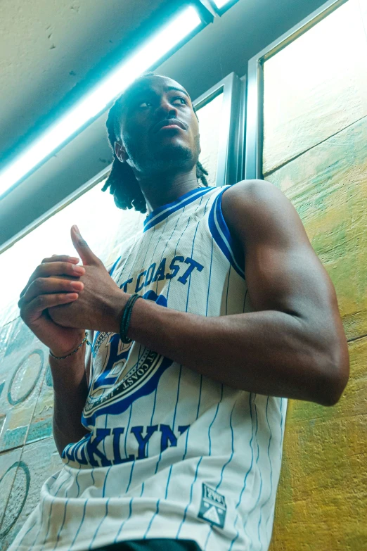 a man wearing a white and blue jersey holding a basketball