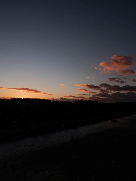 the silhouette of a person walking across a bridge at sunset