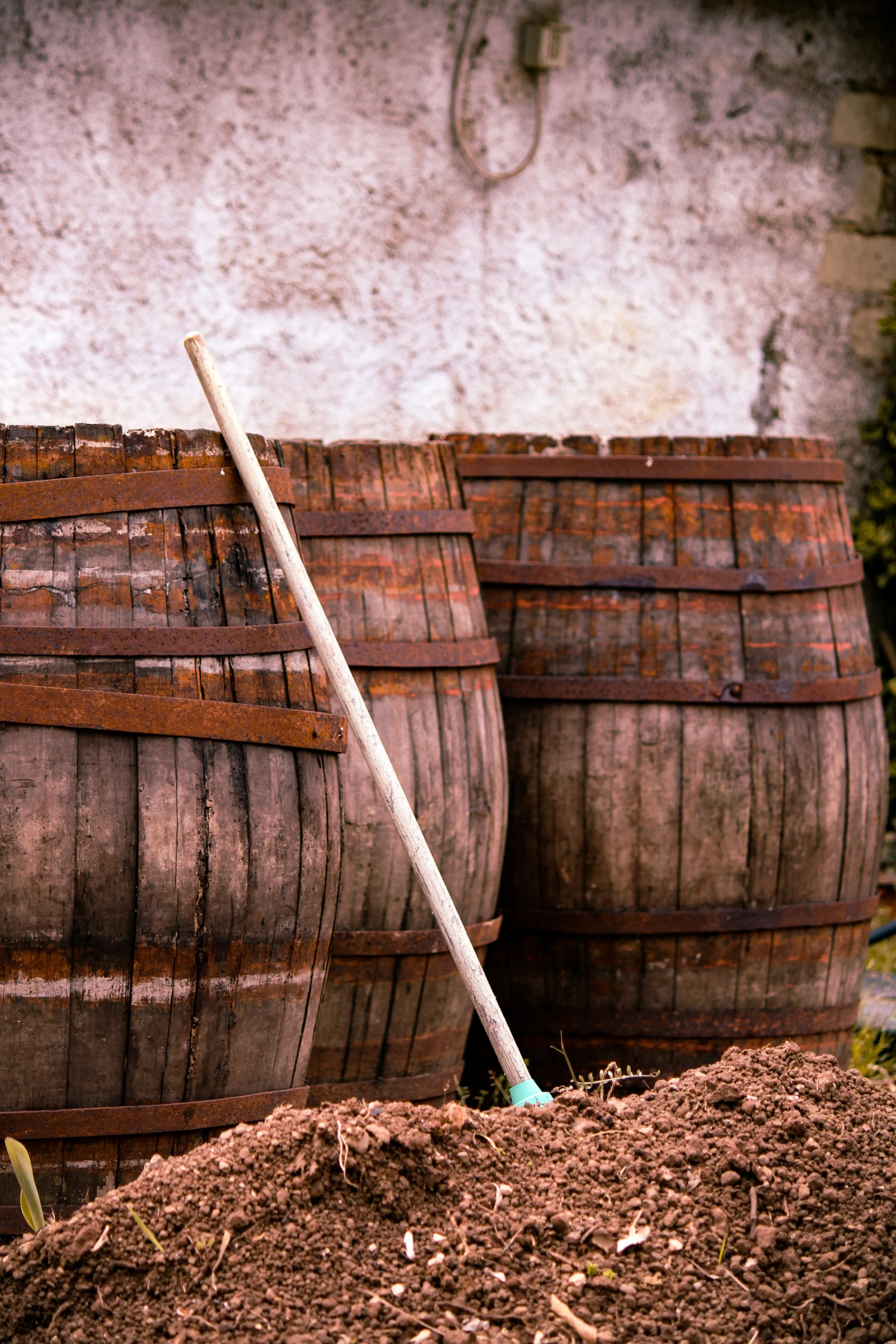 barrels stacked up next to each other with a wooden stick sticking out of them