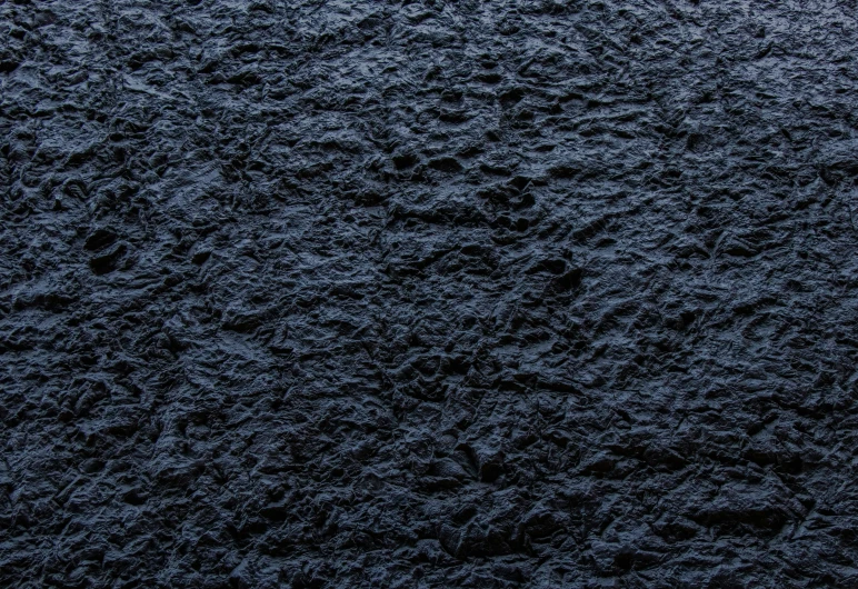 close up image of black, shiny sand