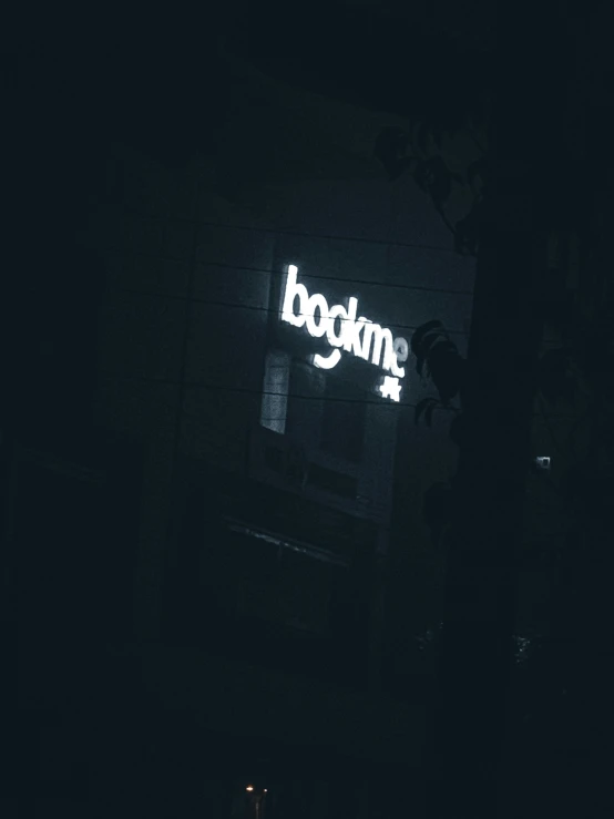 a person looking at the logo of a business at night