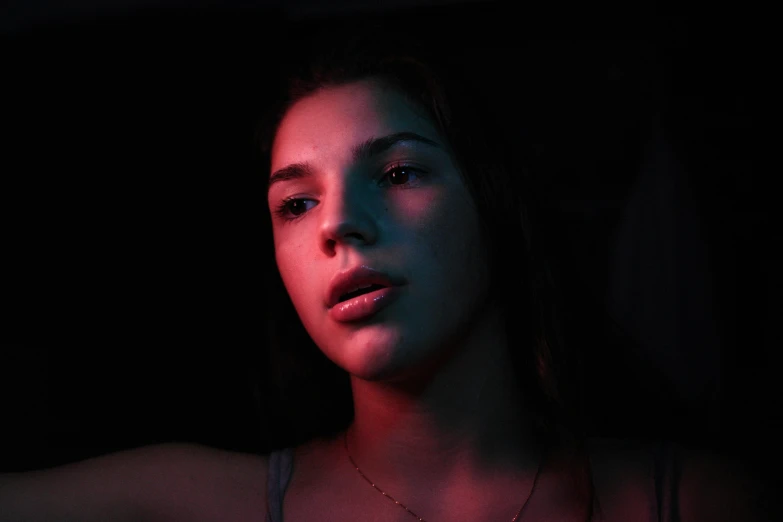 a woman holding an apple with red light in the background