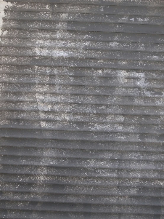 the texture of gray paint on the blinds of an apartment
