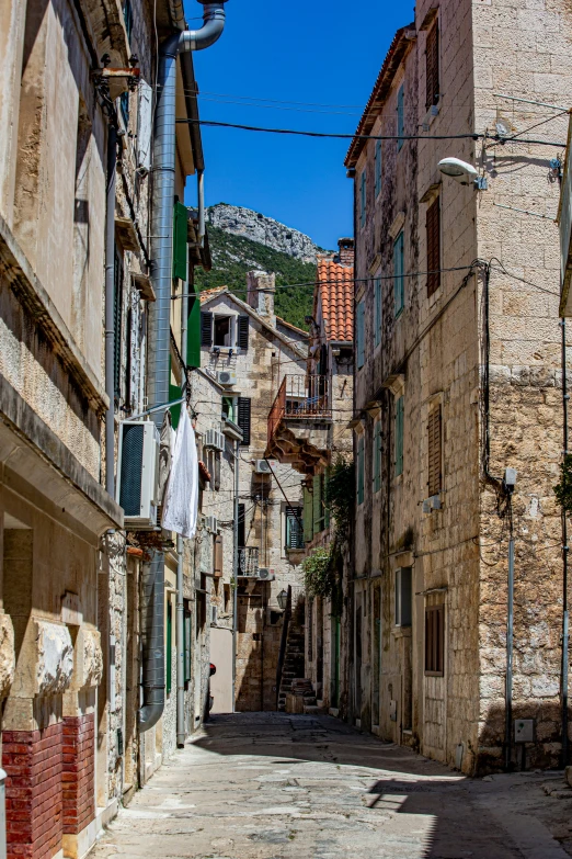 a narrow cobblestone street with buildings on the other side