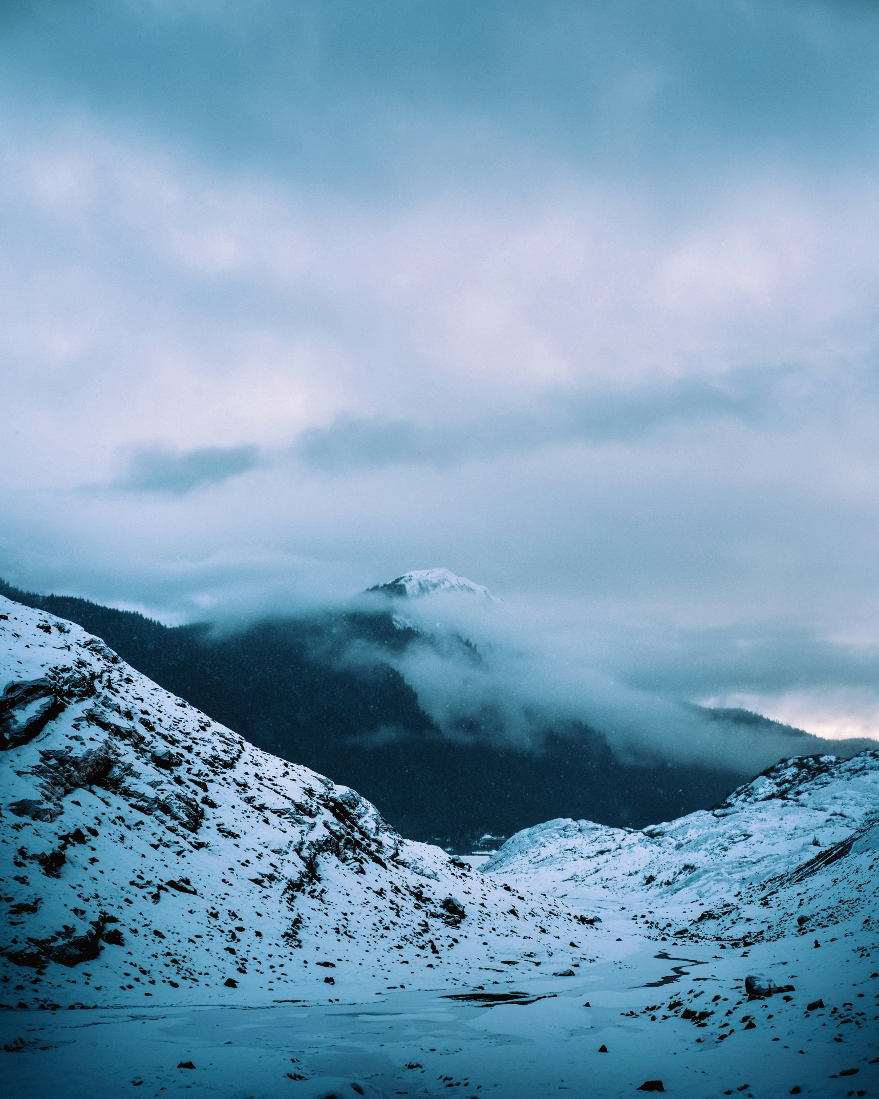 a cloudy sky over mountains with a sky filled with clouds