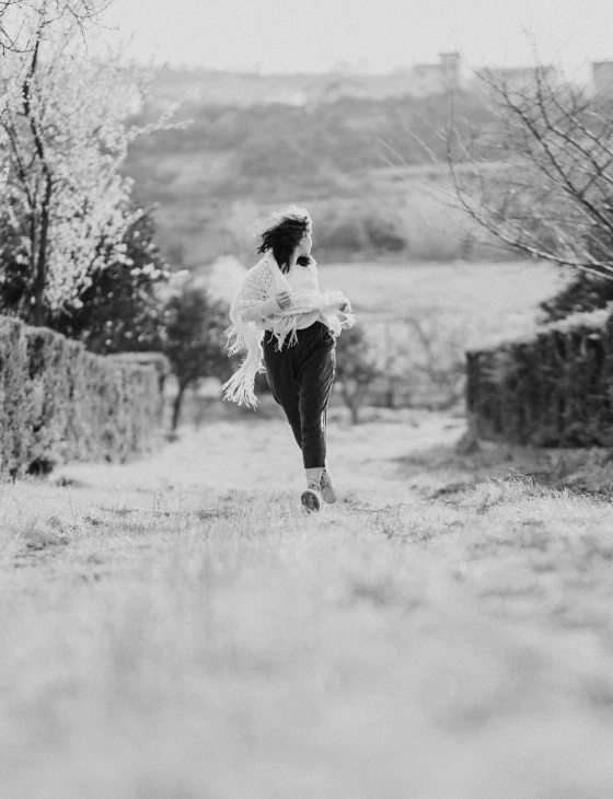 a person standing in a field near a wall