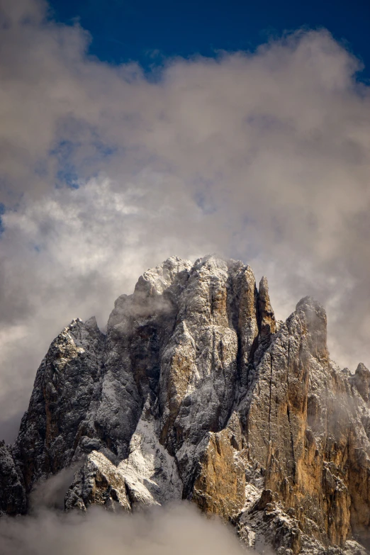 a mountain covered in lots of snow on top of a cloudy sky