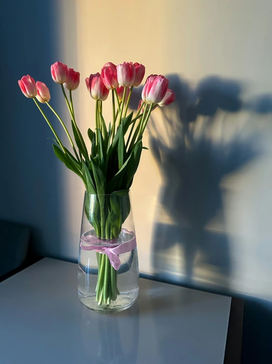 a vase with lots of pretty pink flowers in it