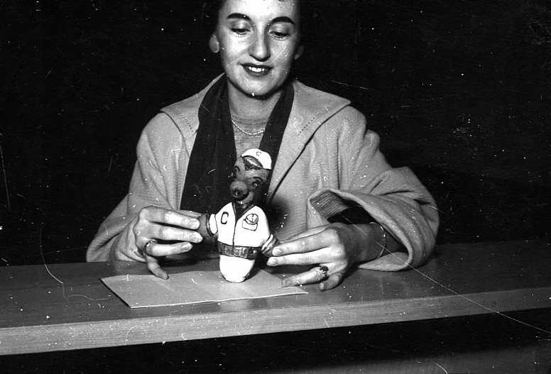 black and white po of a woman holding a cat doll