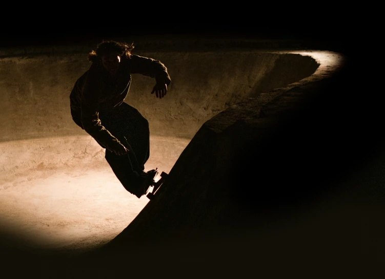 skate boarder riding up the side of a ramp at night