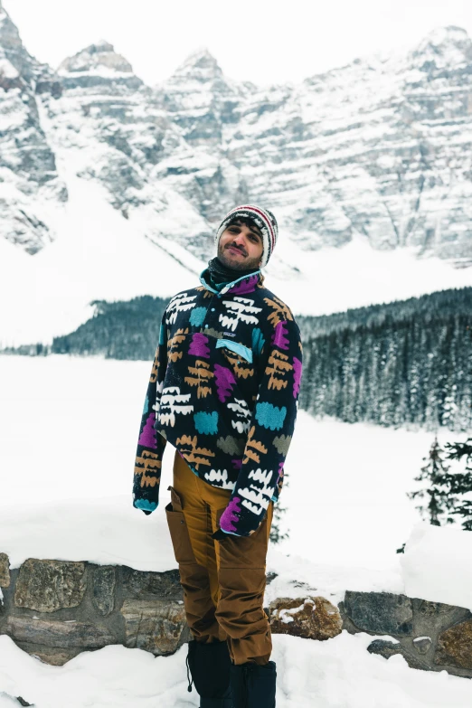 a man standing on top of snow covered mountains