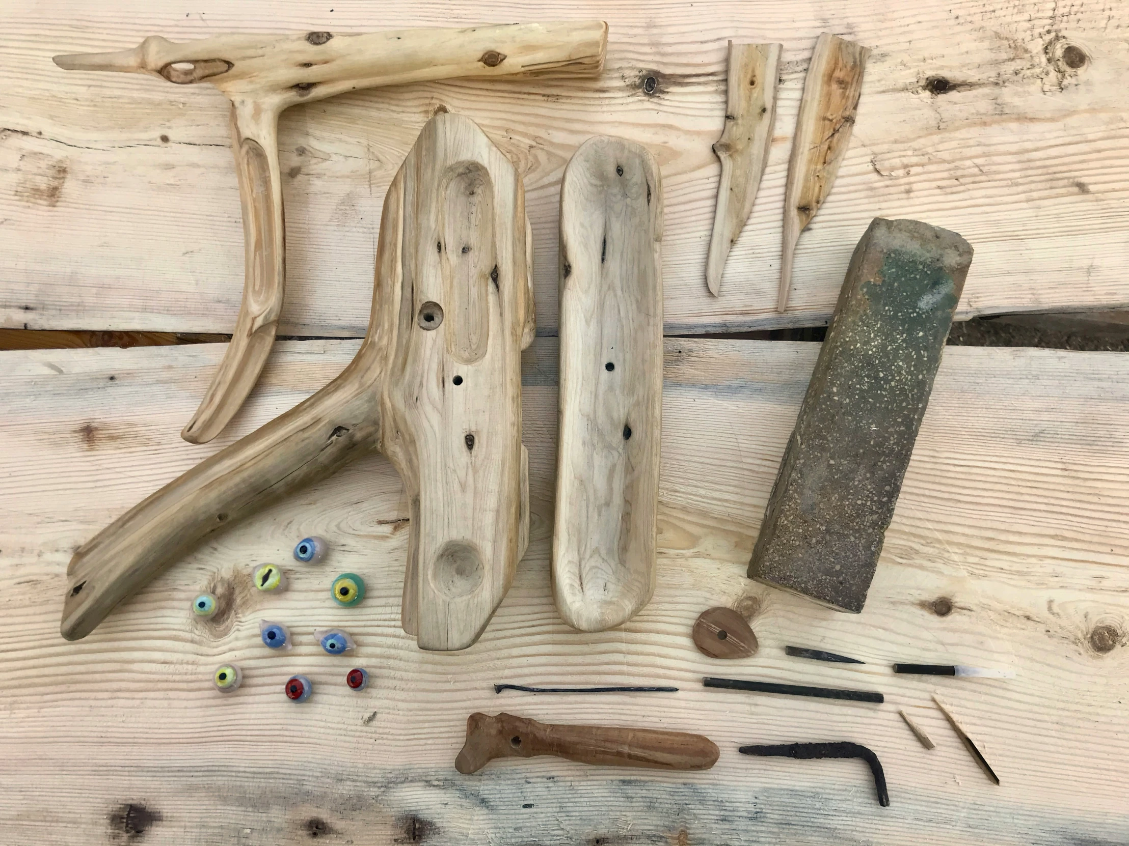 a variety of tools, including hammer and nail, laid out on wood planks