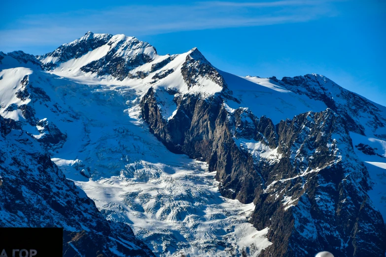 a airplane flies over a snow covered mountain