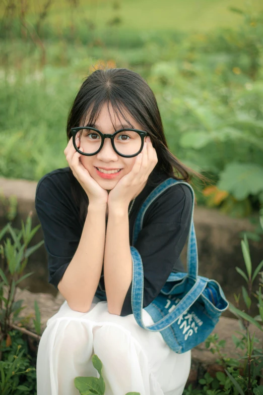 a child with a pair of glasses in front of a garden