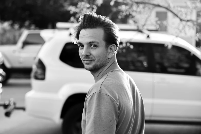 a guy is walking through a parking lot and is looking at the camera