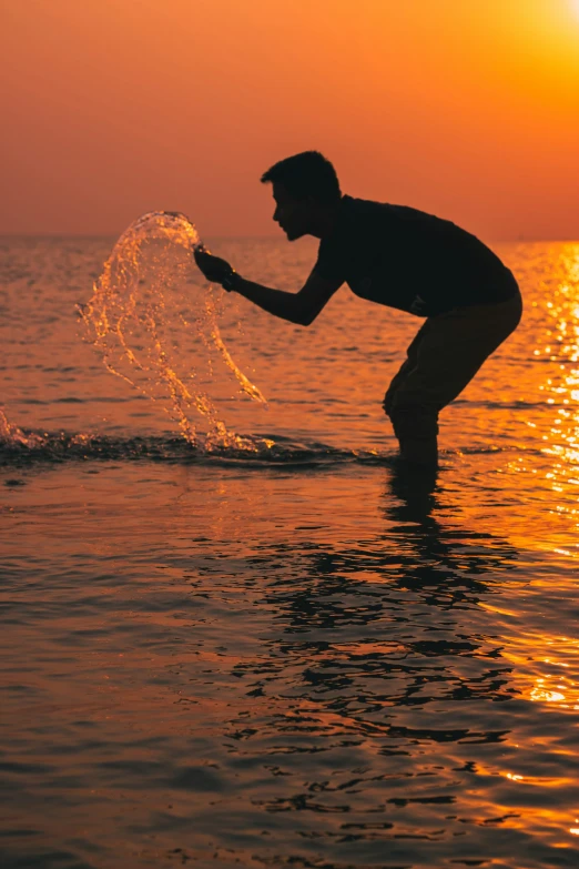 man on surfboard with orange sunset in the background