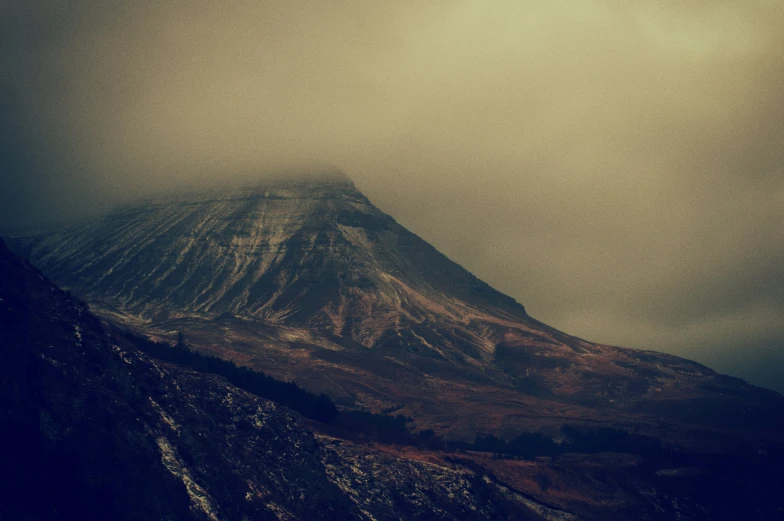 a snow covered mountain is pictured on a foggy day