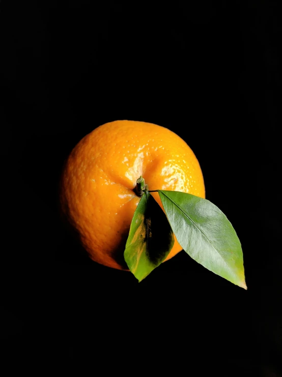 the orange has been placed on top of a black surface