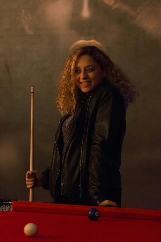 a girl with long blonde hair posing at a pool table