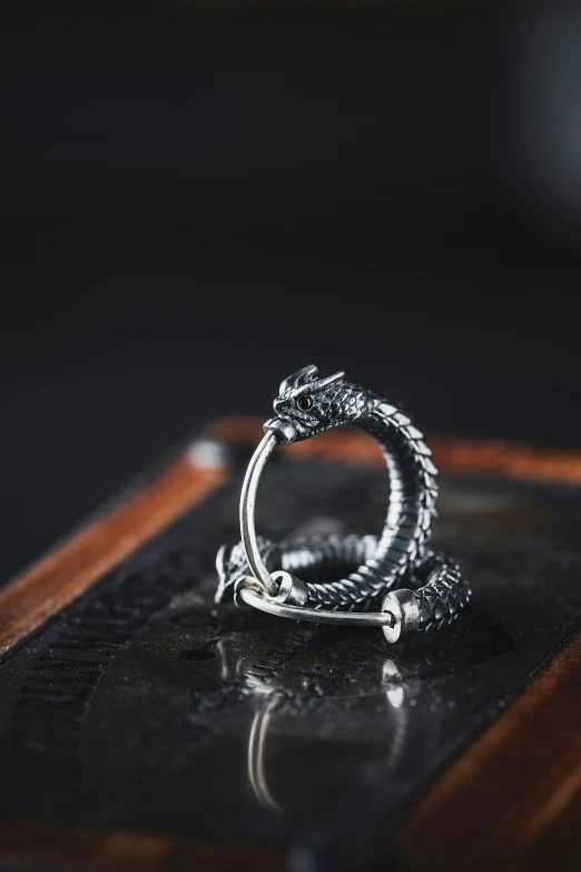 a snake head ring is placed on top of a black tray