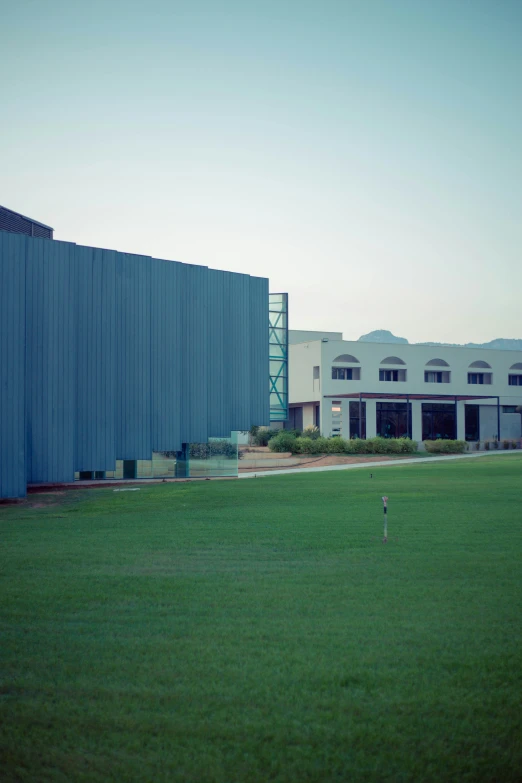 the building has blue walls and grass on the ground