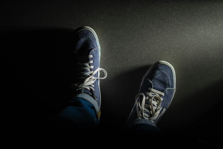 a person in blue sneakers on the side of the room