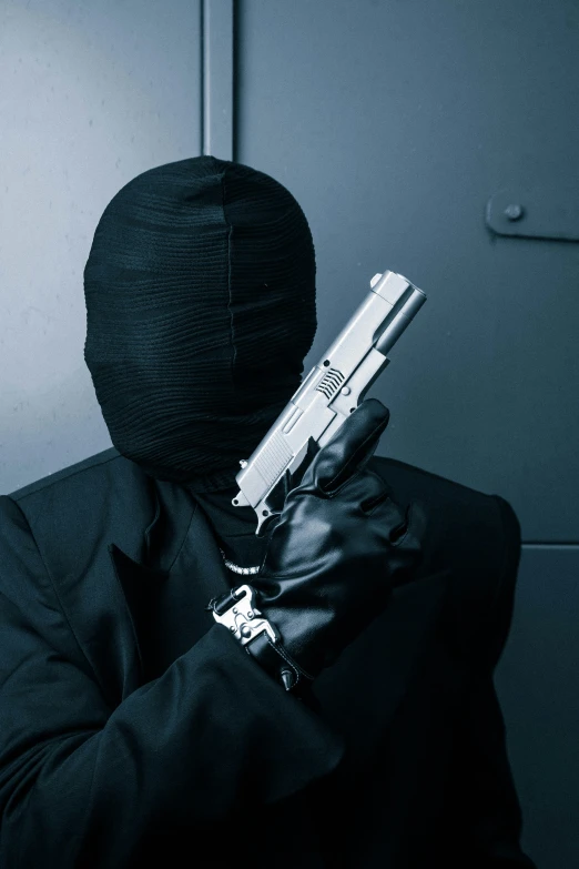 a person in a suit and glove with a gun