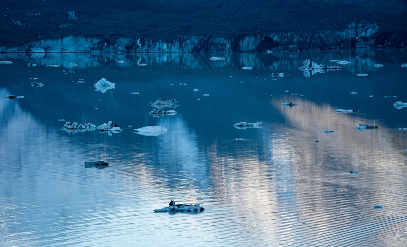 several boats and people on water under a cloudy sky