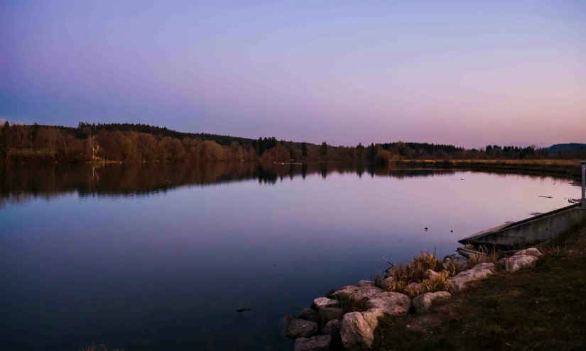 the empty boat sits on the bank of the lake