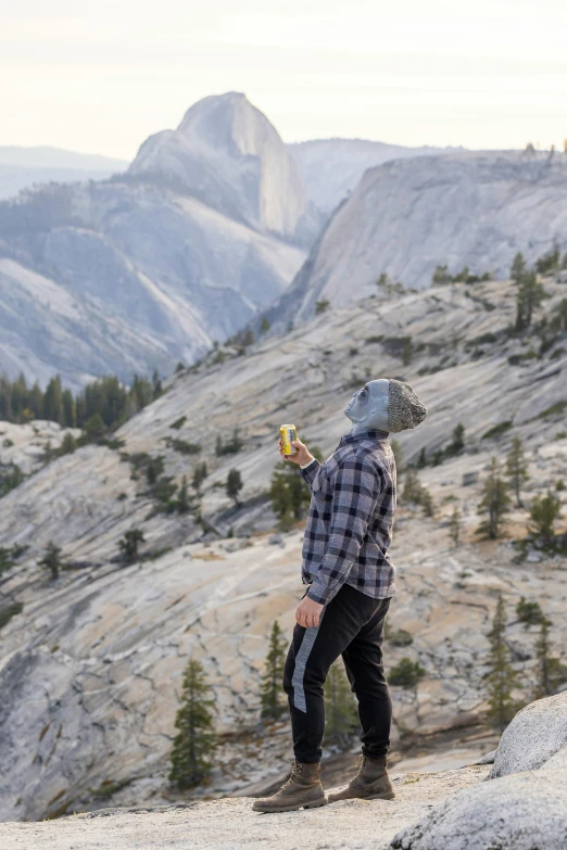 a man stands looking down at mountains and rocks