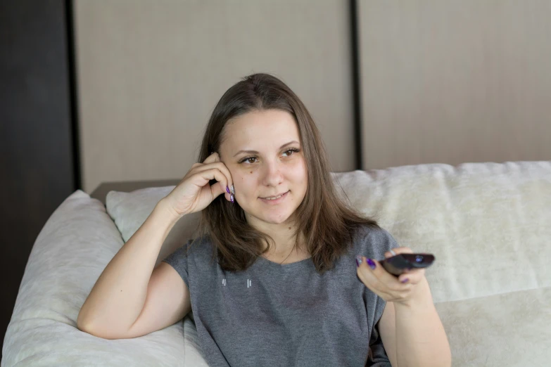 a beautiful young lady holding a remote control and pointing