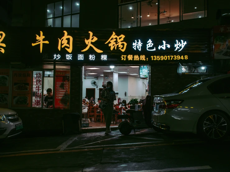 a man walking into a chinese restaurant at night