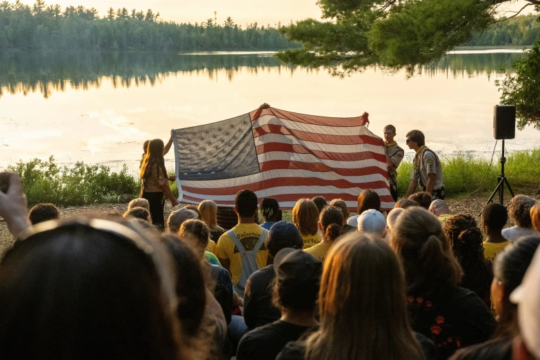 several people in a crowd are holding up an american flag