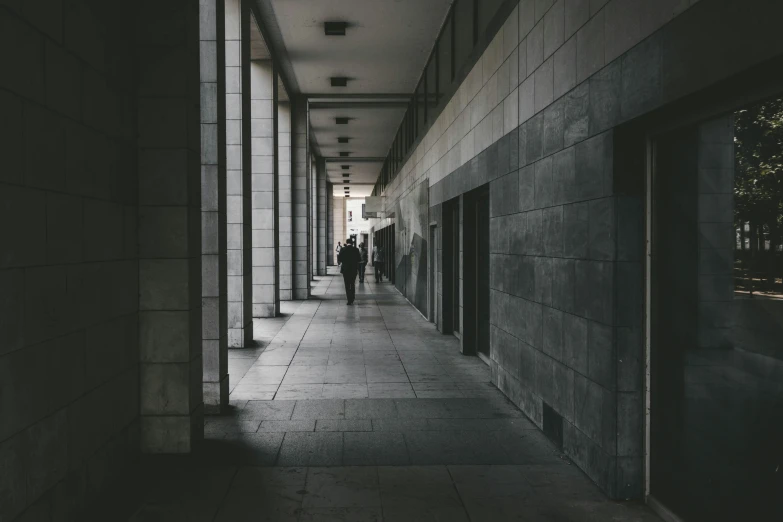 two men are walking down a hallway near the building