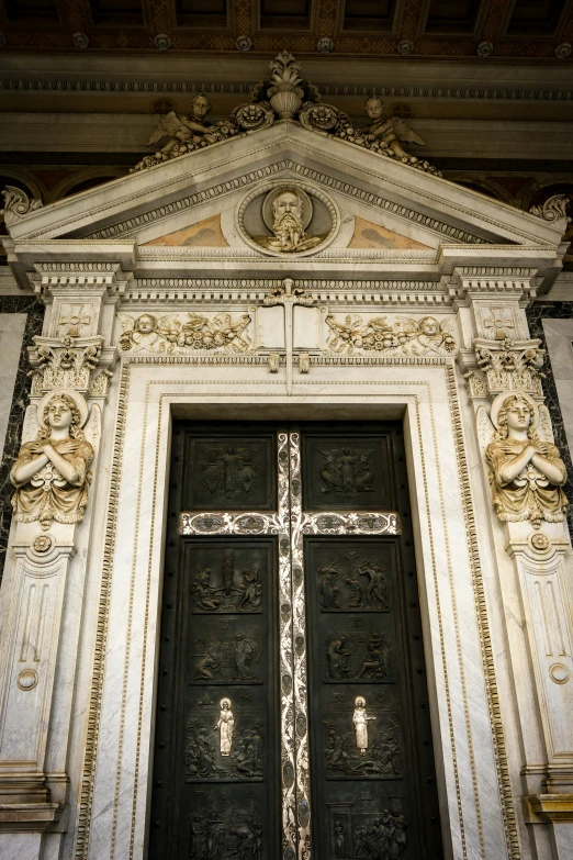 a tall black and white door with a cross at the top