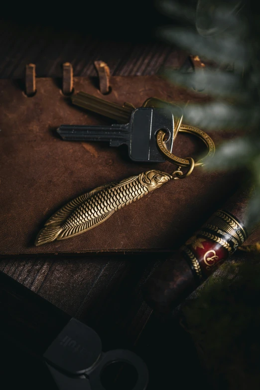 a pen, key and keyring sitting on a leather journal
