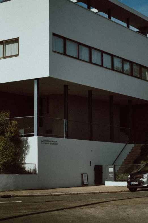 a white building with two cars parked in front