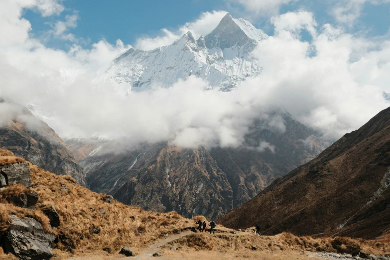 several hikers trekking the path towards a snow - capped mountain