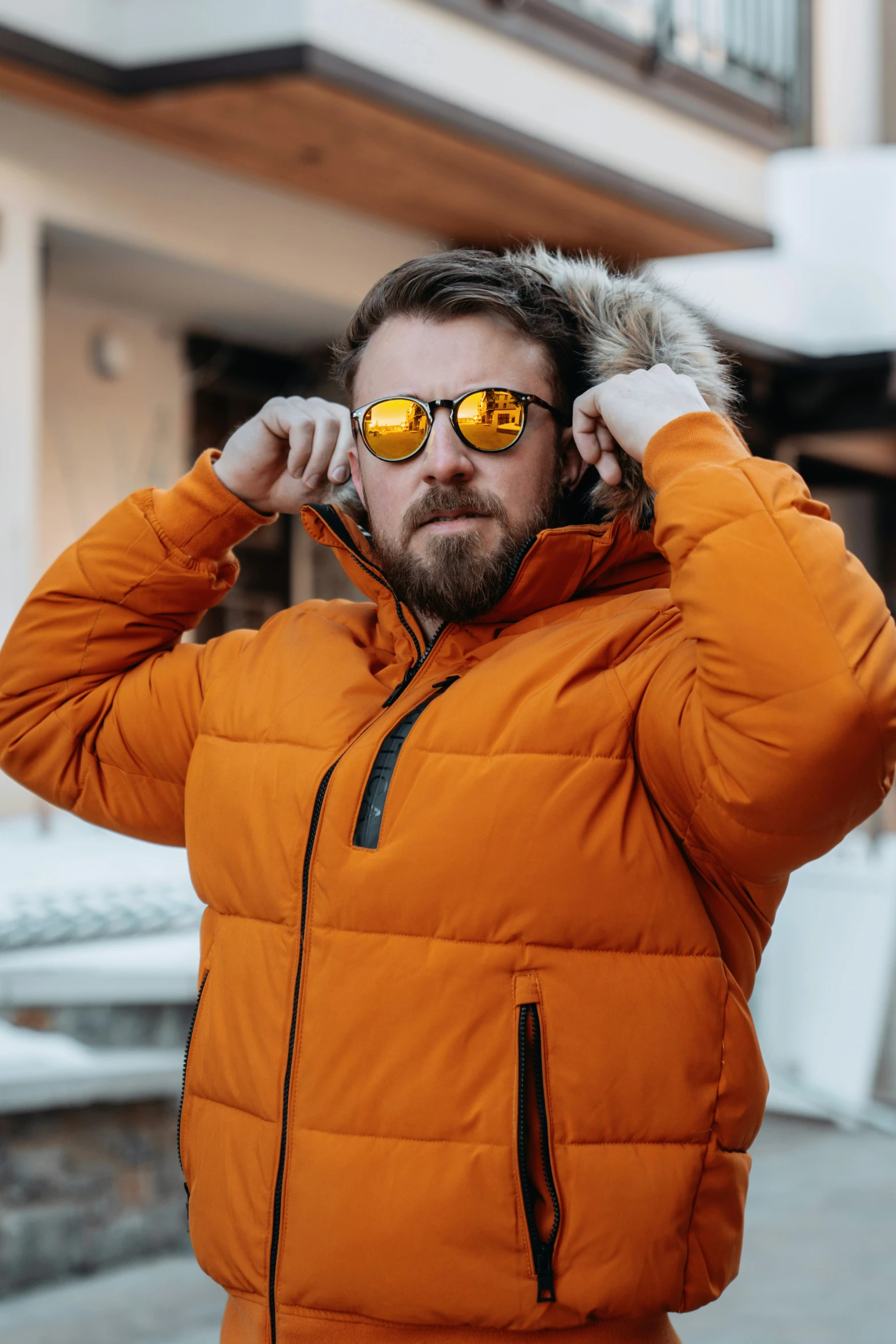 man in orange jacket with a furry hoodie on