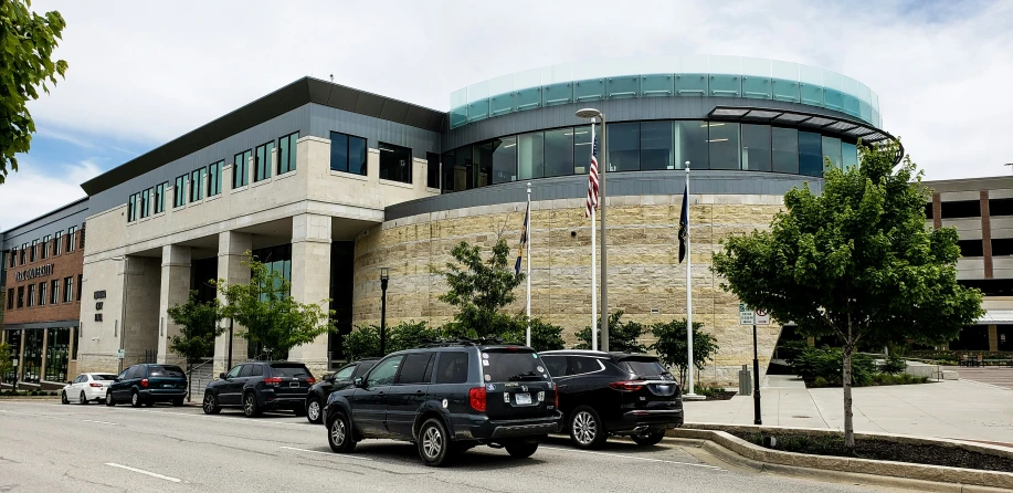 vehicles in a parking lot next to a large building