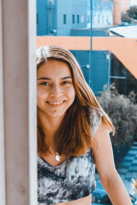 a young woman smiling in the window sill