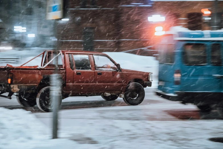 the pickup truck is red and there are many snowed around