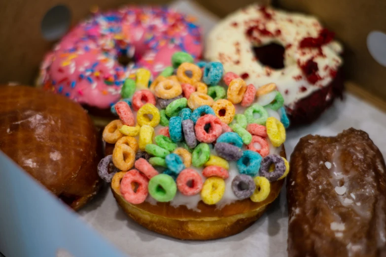 an assortment of donuts in a box filled with sprinkles