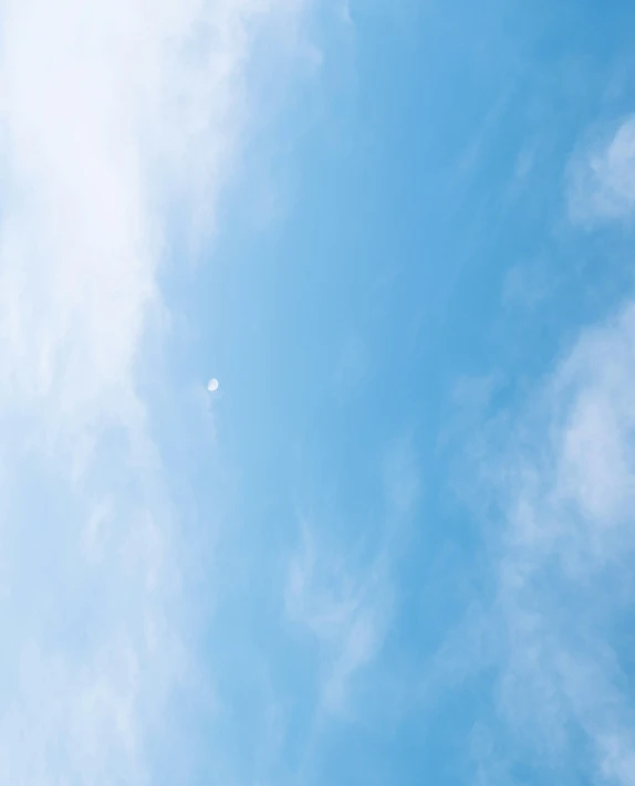 an airplane flying above the clouds in a blue sky