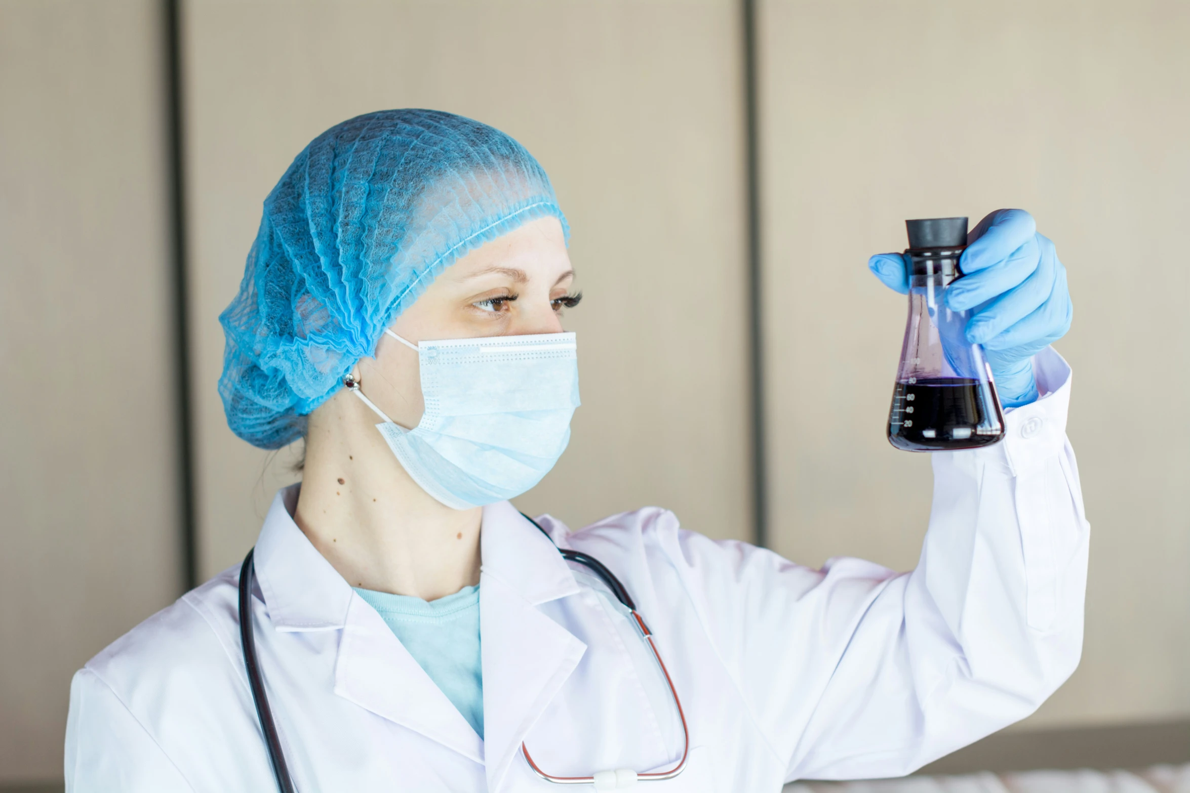 a woman wearing a surgical mask holding an empty flask