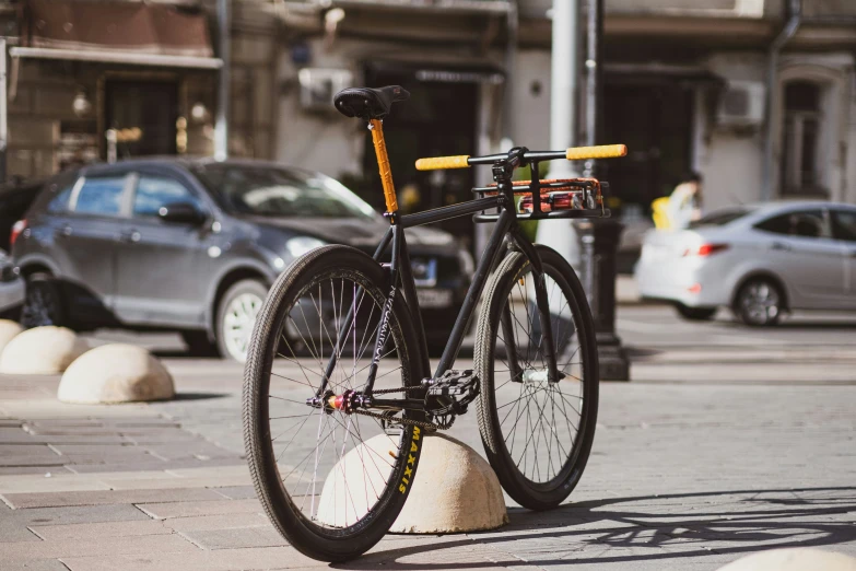 bike parked up against a pole on the side of a street