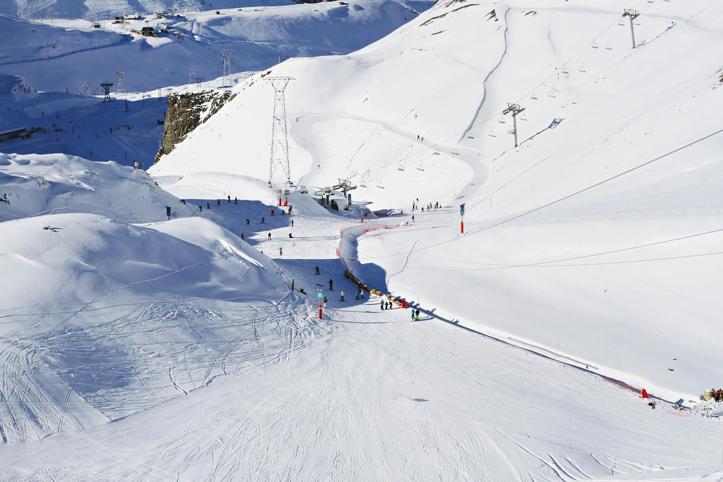 many people skiing and snowboarding on a mountain slope