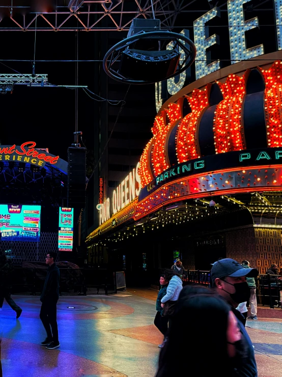 people walk through a mall under a lot of neon signs