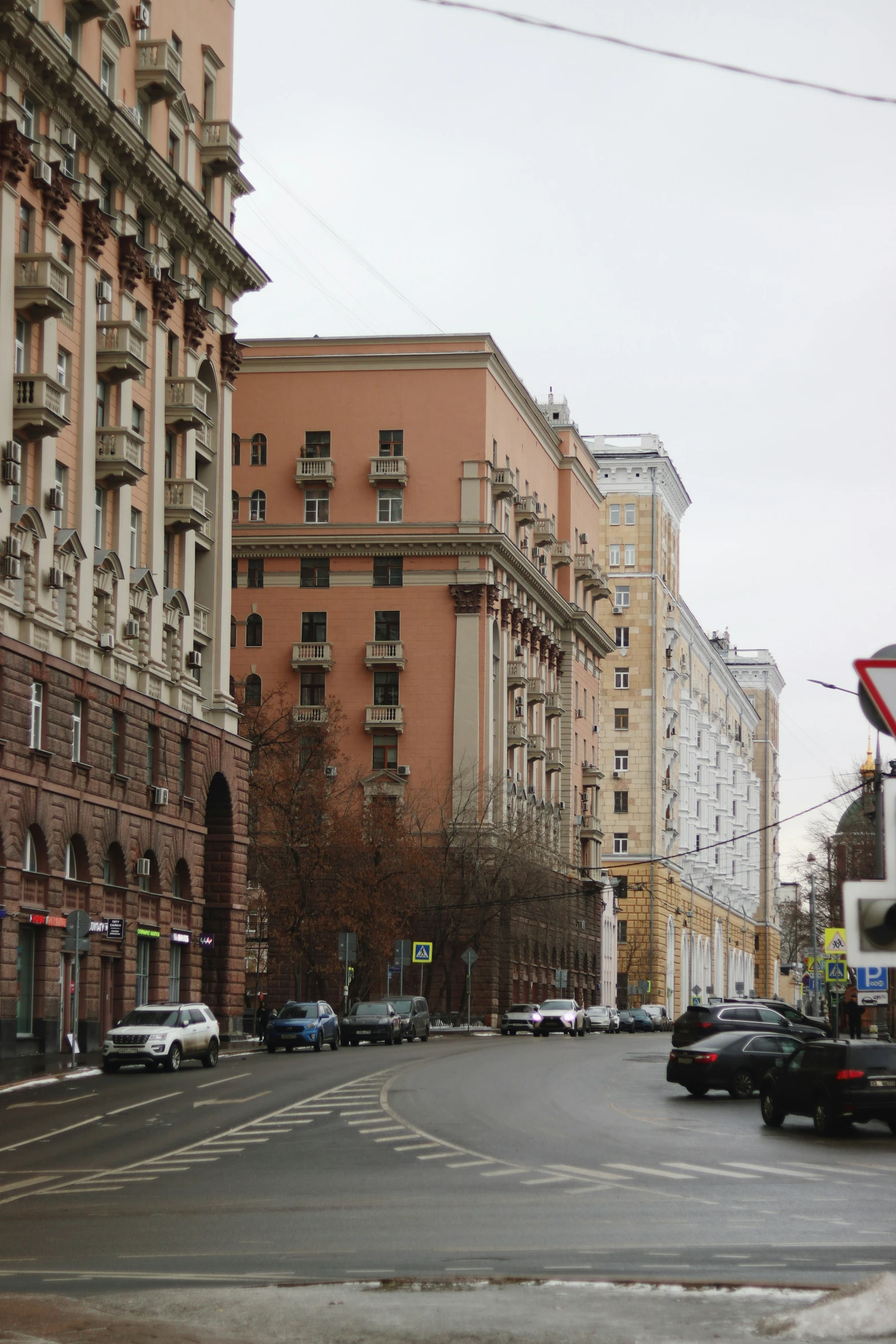 several cars on a road near tall buildings