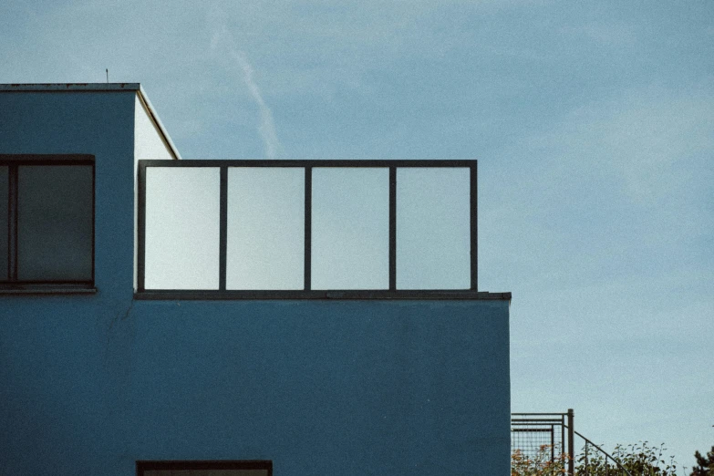 blue building with balconies and a light rail on top